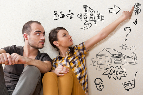 Two people calculating costs of a home through diagrams