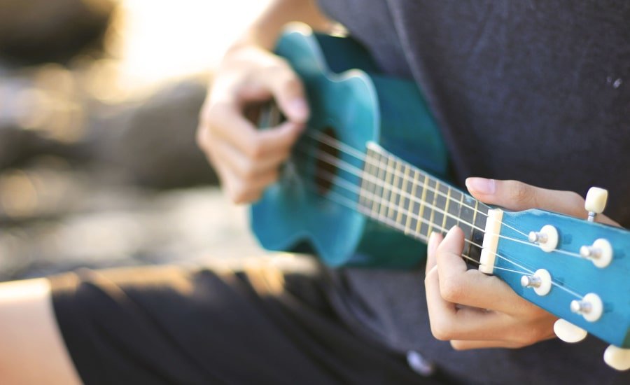 Person playing blue ukulele