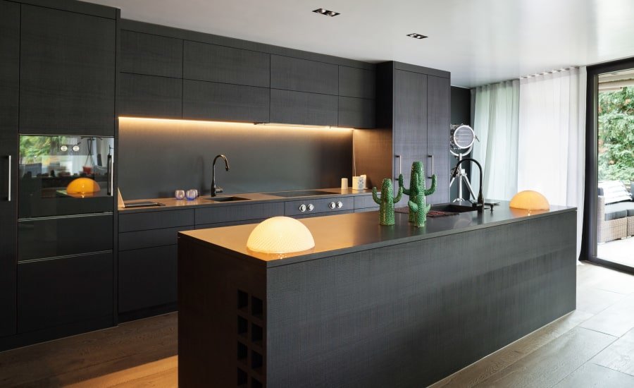 Contemporary dark wood kitchen with orange light and accent pieces