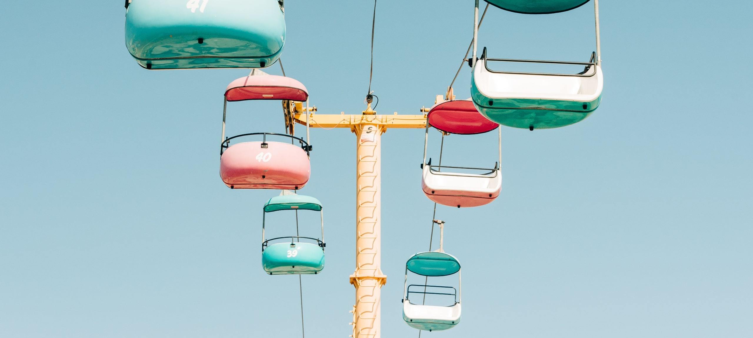 Pastel swings on ride at Santa Cruz Boardwalk with blue sky