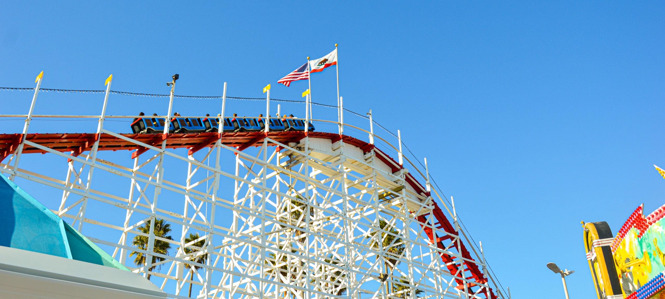Upwards view of rollercoaster at Santa Cruz Boardwalk during summertime. Sourajit Karmakar on Unsplash