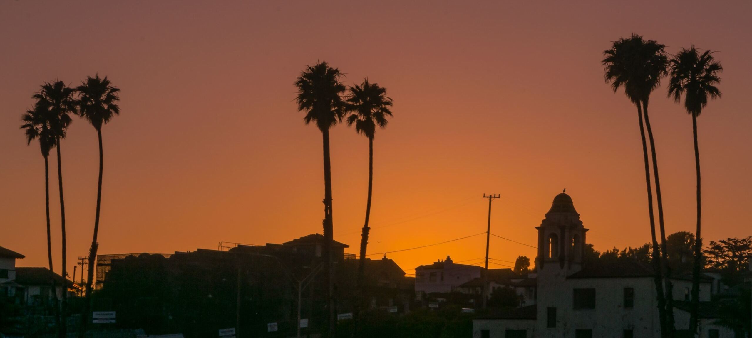 Orange sunset over silhouettes of downtown Santa Cruz, CA. Photo by Abhishek Rao on Unsplash 