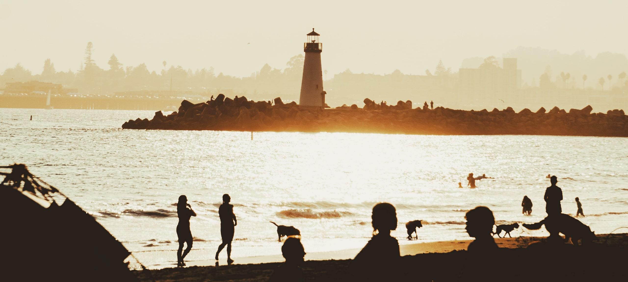 Silhouettes of beachgoers at Lighthouse Beach in Santa Cruz, CA. Photo by Luis Angelo on Unsplash
