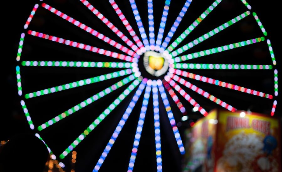 Colorful Ferris Wheel spinning at night at county fair, Santa Cruz