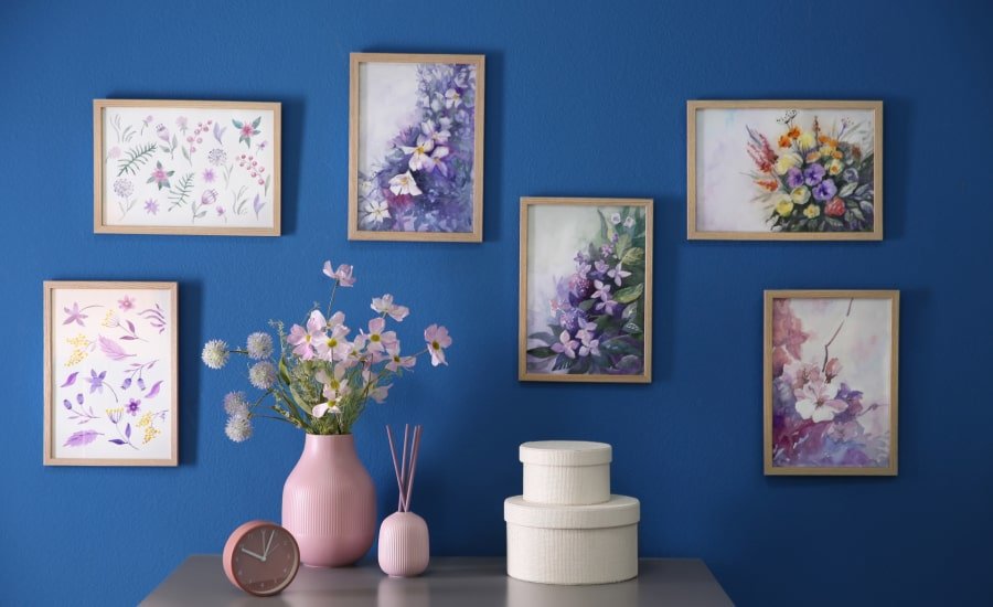 Floral artwork on blue wall behind contemporary table