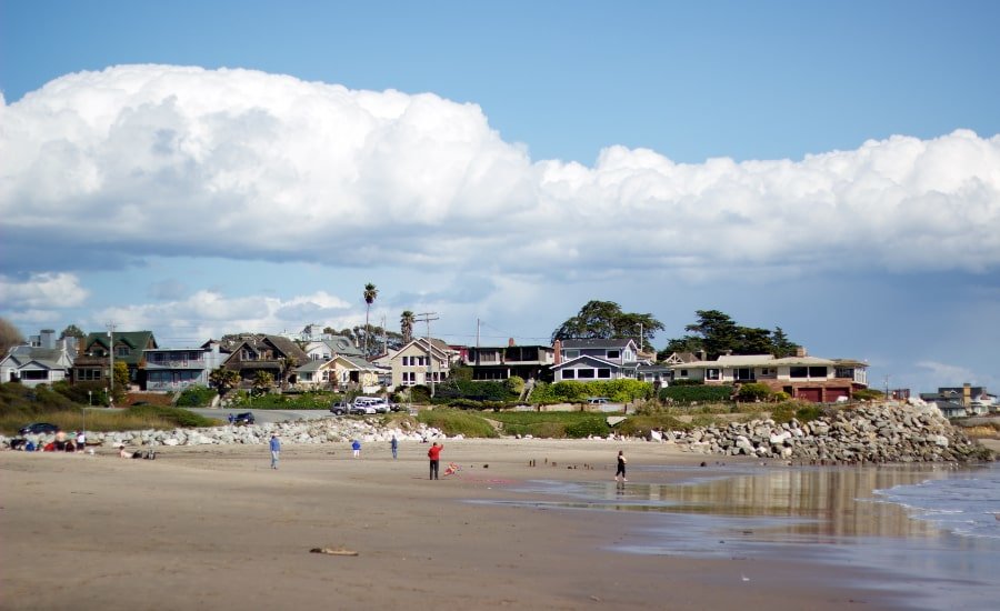 Figures on Twin Lakes State Beach, east of Santa Cruz, with homes in background