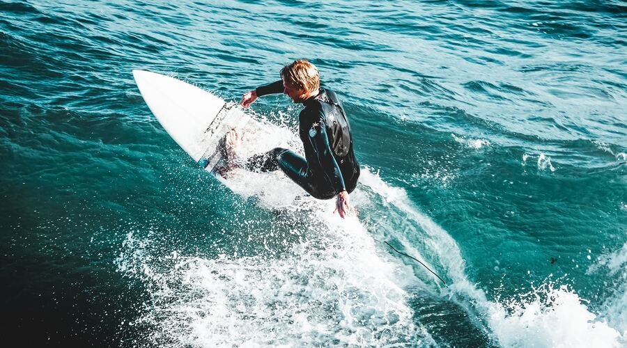 Surfer on waves off the coast of Santa Cruz. Photo by Emily Hoehenrieder on Unplash