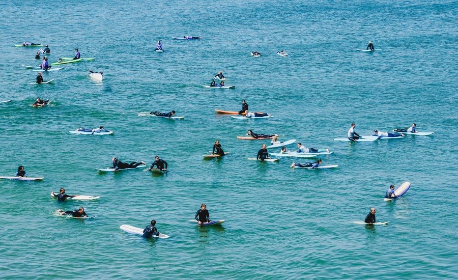 Surfers on boards in the Santa Cruz ocean. Photo by Emily Hoehenrieder on Unsplash